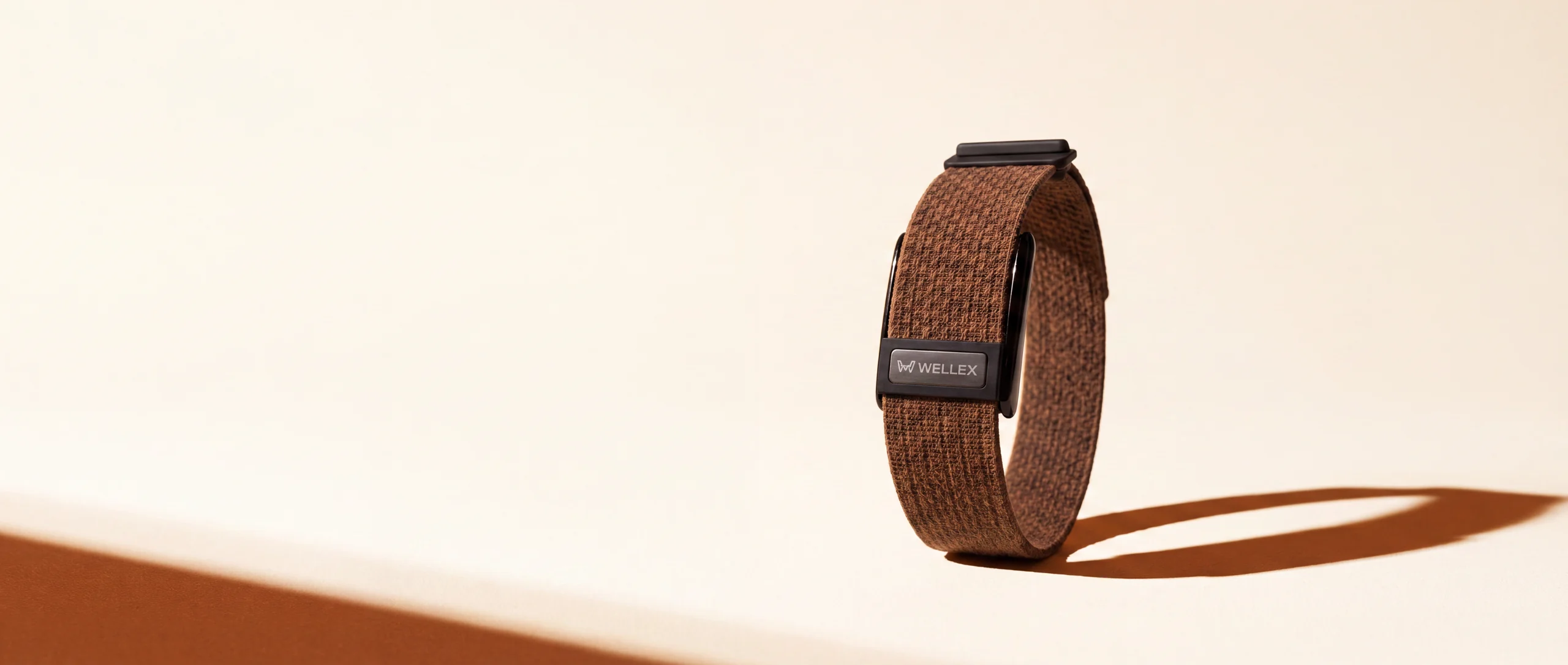 A Wellex band on a cream background in raking light