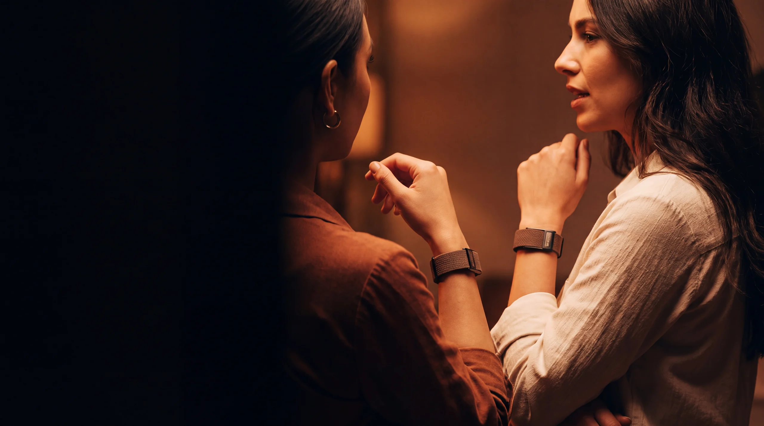 Two people in conversation, both wearing Wellex bands